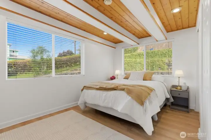 Primary bedroom with wood ceiling and loads of natural lighting