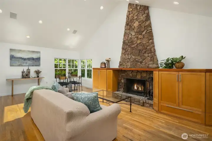 Built-in media cabinets surround the inviting stone fireplace.