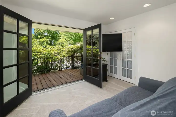 French doors open to your private balcony with a screen of lush vines.