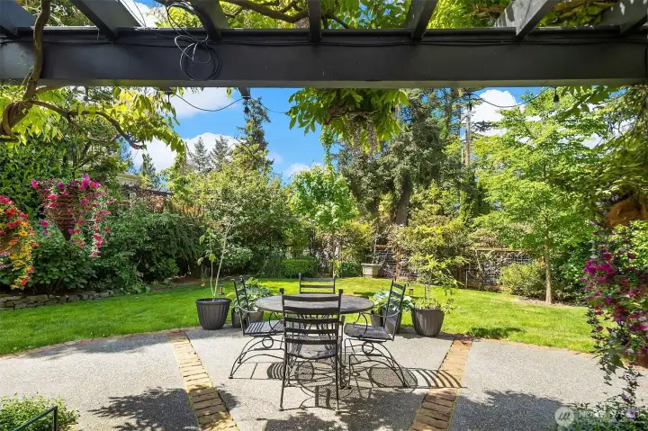 Secluded backyard oasis with a sunny patio & verdant landscaping.