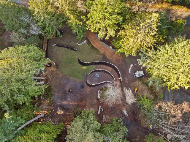 A bird's eye view of the building site, showing graceful berms and landscaping.