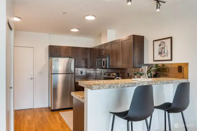 Updated kitchen with granite counter top,  stainless appliances, and bar seating.