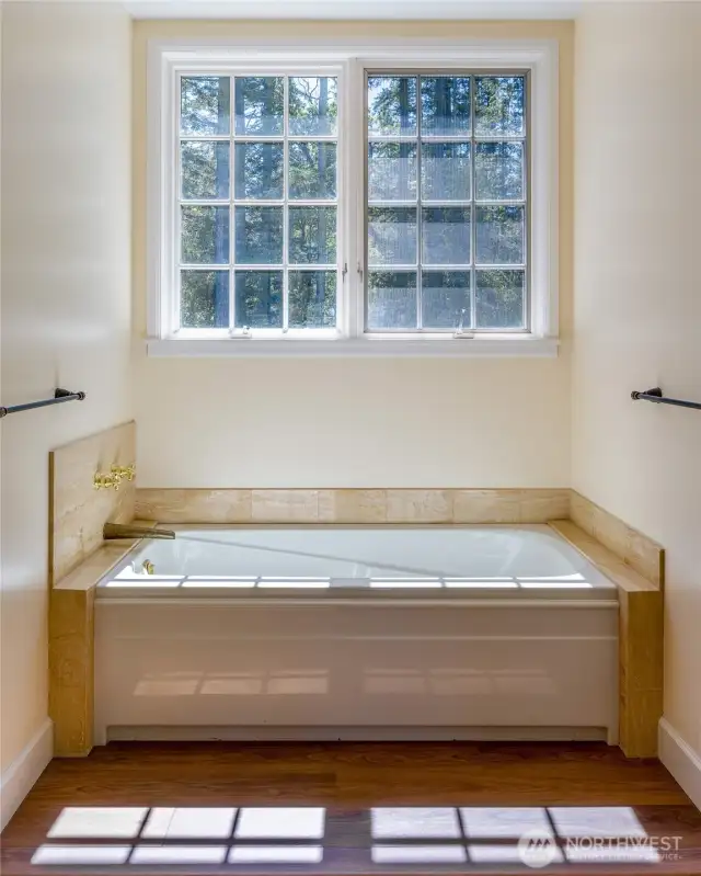 Bathtub alcove in the primary bathroom is adjacent to the separate shower.