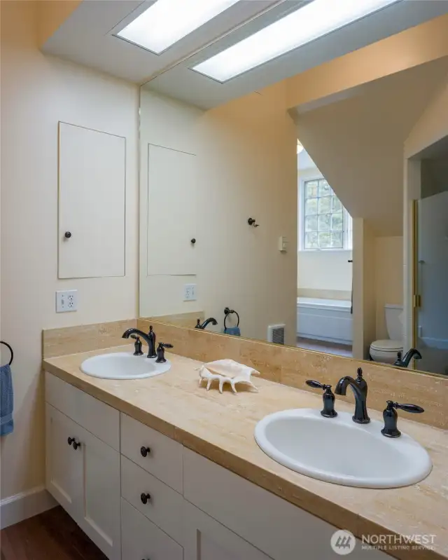 Primary bathroom.  You can see a reflection of the separate shower in the mirror.