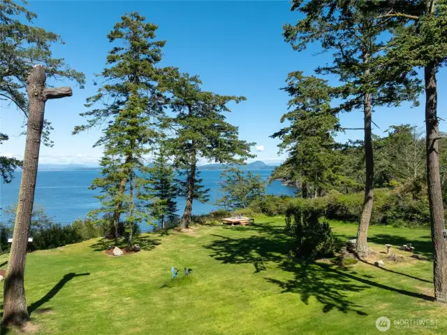 Sunny yard for all your outdoor activities with small viewing deck just top of the bank.  Just out of sight is the small, fenced garden.