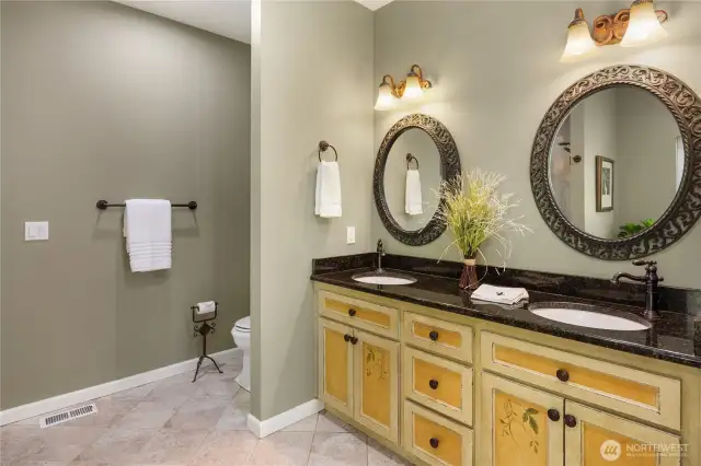 Dual sinks with custom painted cabinets and granite counters.