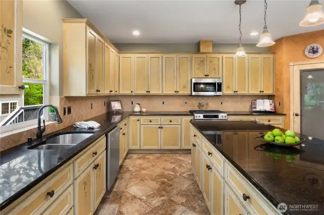 The hand painted custom cabinetry is topped with granite countertops, and offers beautiful travertine floors.