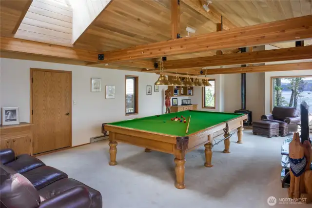 Snooker table (larger than pool table) room with door to wood storage for the wood stove. Slider to deck just out of sight to right of brown chair.  Pocket doors can separate this room from Great Room.