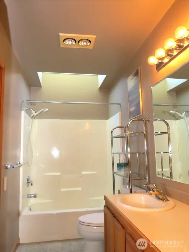 OPENING INTO THE PRIMARY ATTACHED BATH THAT HAS A SKYLIGHT OVER THE TUB/SHOWER COMBINATION!