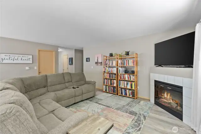 The living room is warm and inviting, featuring large windows that flood the space with natural light and a cozy gas fireplace for those chilly Northwest evenings.