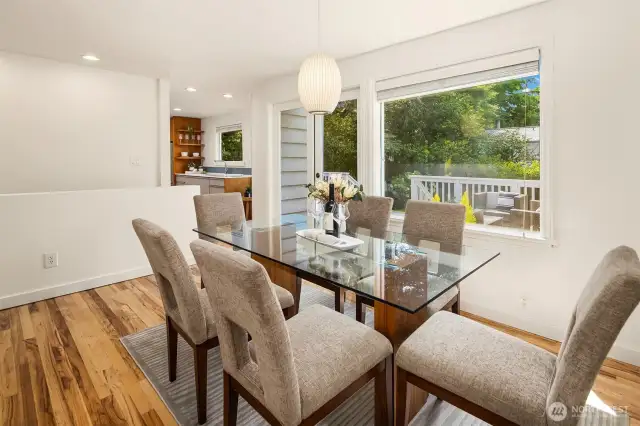 Dining area framed by large windows and French doors providing access to outdoor space.