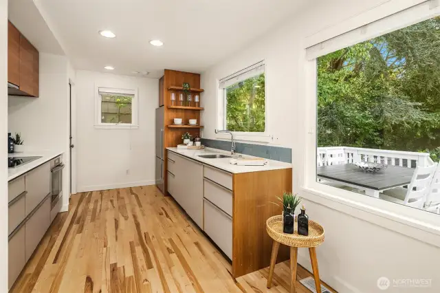 Modern kitchen overlooking deck + backyard.