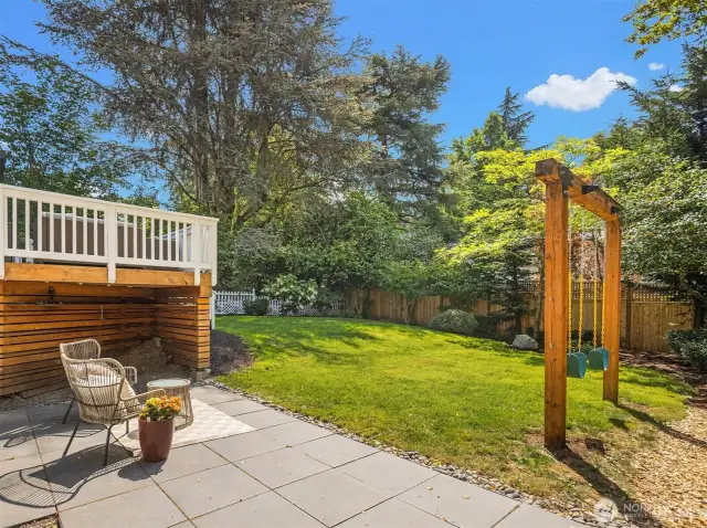 Lower patio area looking out to large, fully fenced backyard.