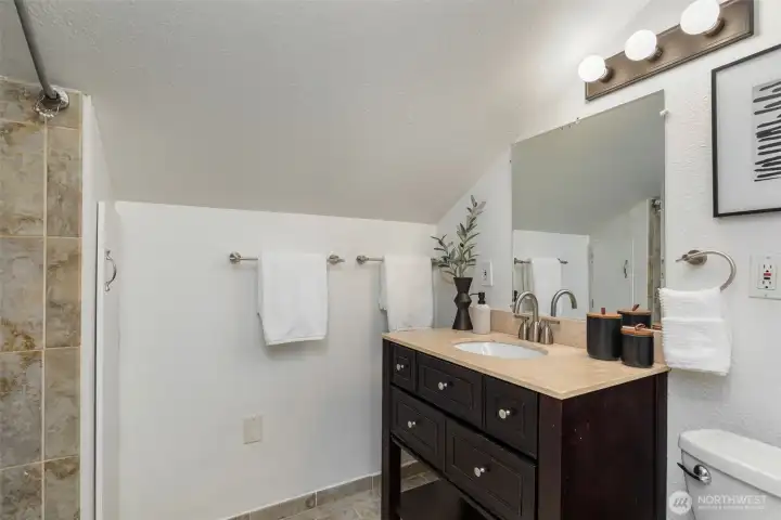 Full bathroom nicely appointed with tile flooring and stylish vanity.