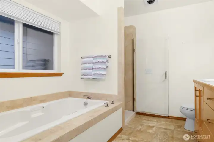 The soaking tub and shower in the primary bathroom.