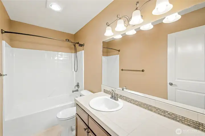 Upstairs full sized guest bathroom with ample storage and counter space.