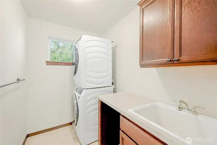 Upstairs laundry room with plenty of storage and utility sink.