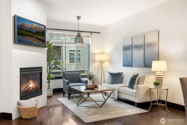 Main-level living room with gas fireplace and expansive windows.