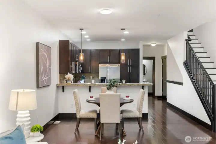 Kitchen with dark wood cabinetry, granite countertops, and stainless steel appliances.