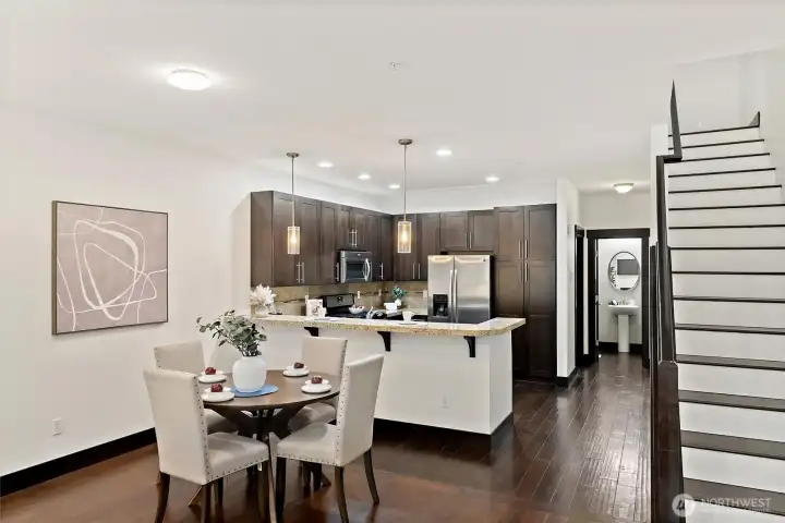 Open kitchen and dining perspective showing attached granite peninsula.