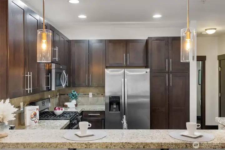 Granite peninsula with bar seating and pendant lighting—perfect for casual dining.