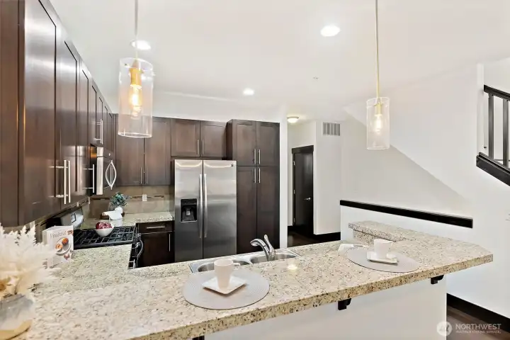 Kitchen peninsula viewed from the living side, emphasizing open-concept design.
