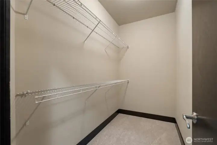 Walk-in closet with built-in shelving system for organized storage.