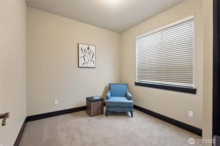 Additional bedroom or office space with large window and neutral palette.
