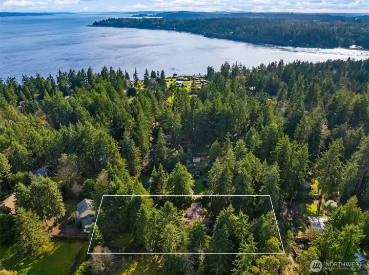 View from above facing south toward Manitou Beach with Puget Sound in the distance (property boundaries are approximate).
