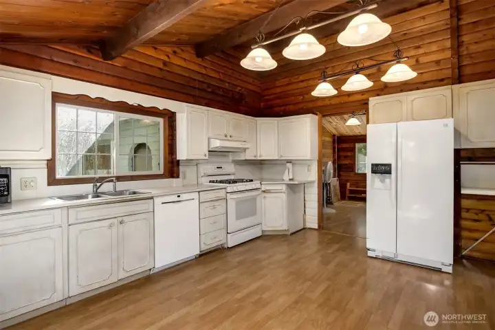 Beyond the kitchen you’ll find a versatile bonus area, perfect for a walk-in pantry or laundry/mud room, with steps leading down to an enclosed carport/shop area (carport/shop not included in house square footage).