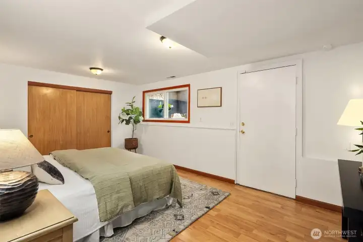 Downstairs bedroom 5 with private exterior access through shop/fitness area.