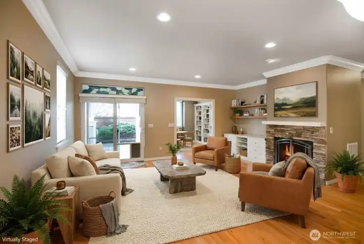 Open living room has crown molding and cozy fireplace.