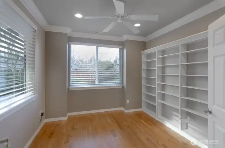 Open den with two large windows overlooking private backyard.