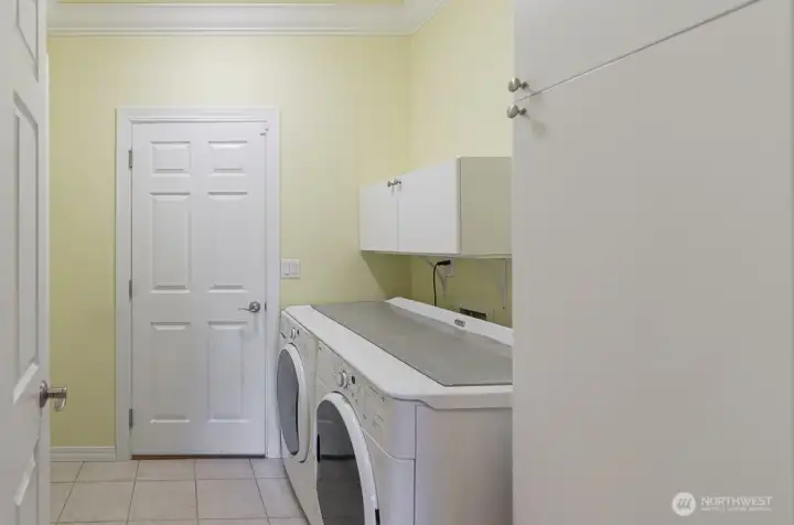 Utility room with added storage. Washer and dryer included. Door leads to oversized two-car garage.