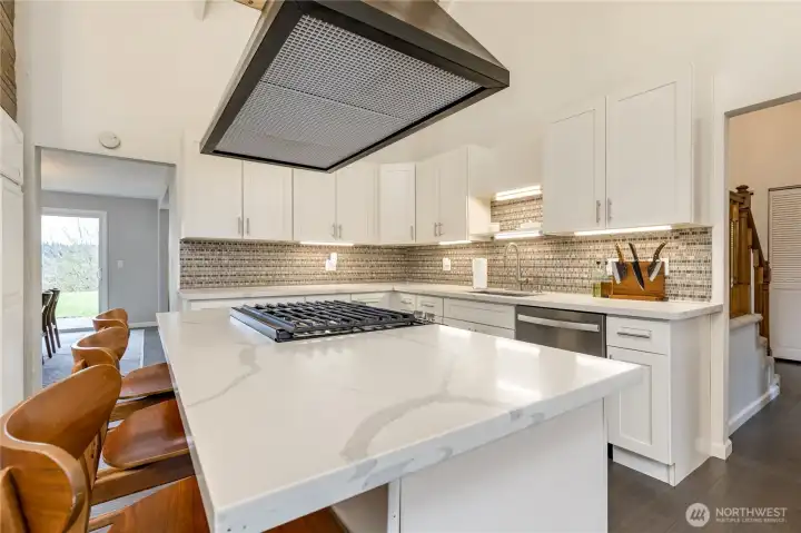 Beautifully-updated kitchen with crisp white cabinetry and sleek quartz counters