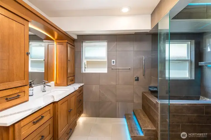 Primary bath with color change LED lights in shower and steps to custom soaking tub