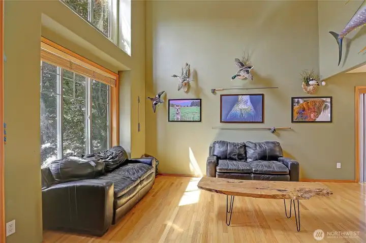 Soaring ceilings and oversized windows create a bright, inviting living room filled with natural light.