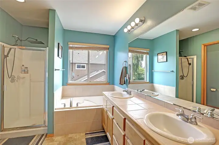 Dual vanities, soaking tub, and separate shower complete the primary ensuite.