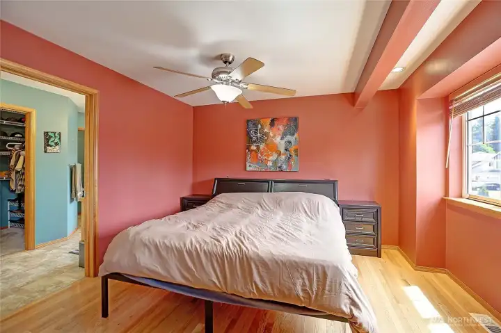 Spacious primary suite with hardwood floors, abundant natural light, and a cozy window nook.