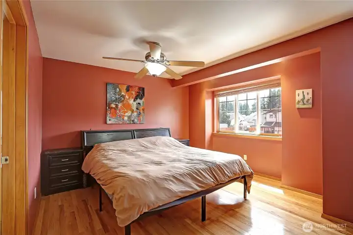 Spacious primary suite with hardwood floors, abundant natural light, and a cozy window nook.