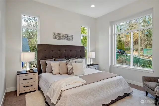 Primary bedroom, large windows flooding natural light