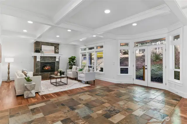 Slate floors lead from the foyer into the open-concept great room with classic box beam ceilings and French doors to a covered back porch