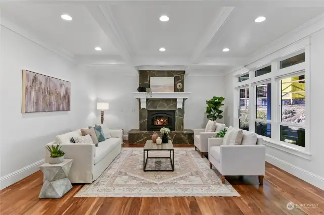 Refinished hardwood floors and a propane fireplace wrapped in stone adorn the living room