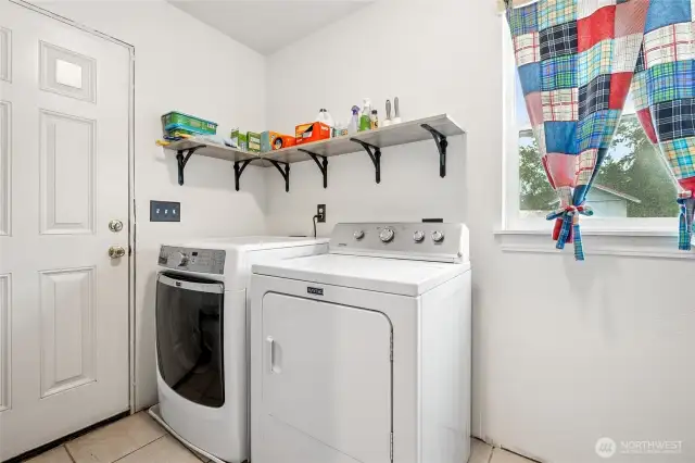 Bright and practical laundry space featuring a door that opens right to the backyard.