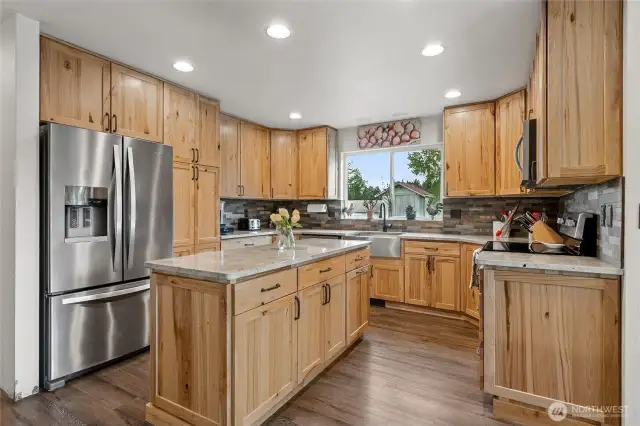 Rustic charm meets modern elegance in this updated kitchen featuring rich hickory cabinets, quartz countertops, and sleek stainless appliances.