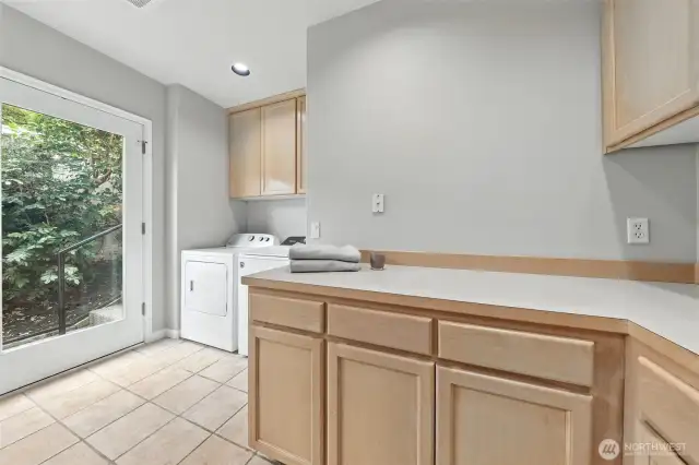The spacious laundry room features tile floors, a large counter and cabinet area as well as a shower. Great for rinsing off after a day on the lake or for a guest that is staying in the main floor den/office.