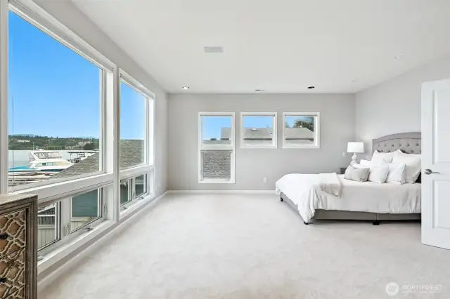 The sumptuous primary bedroom suite is extremely large and boasts wall to ceiling windows that capture the serene views of Lake Washington from every angle.
