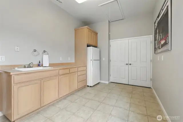 This extra finished room with tile floors, large closet, and partial kitchen with sink and refrigerator  is perfect for a studio space and can be accessed from the exterior walkway as well as the garage.