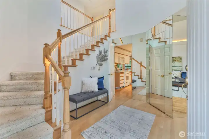 An inviting entry with mirrored accents walls and hardwood floors.