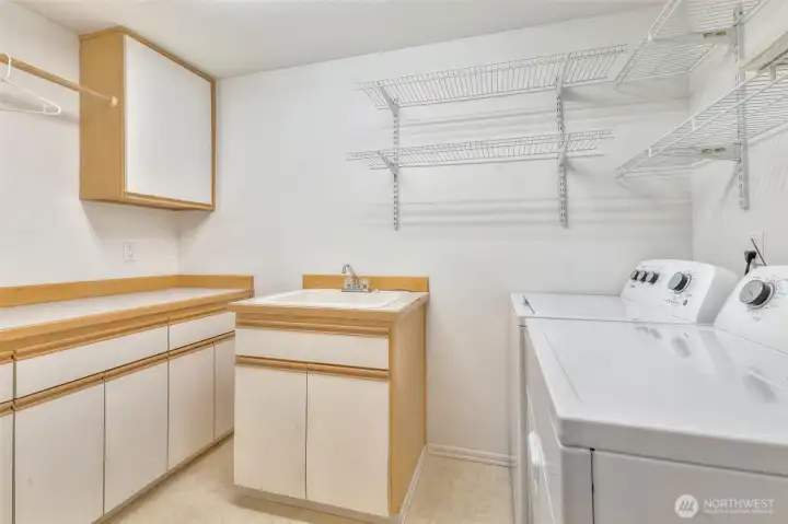 Laundry room with utility sink and lots for storage.